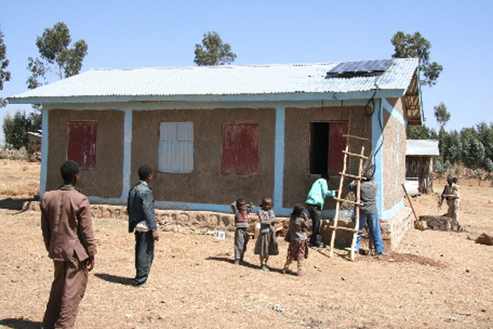 Rural Health post at Beso being fitted with a solar panel to run a vaccine fridge